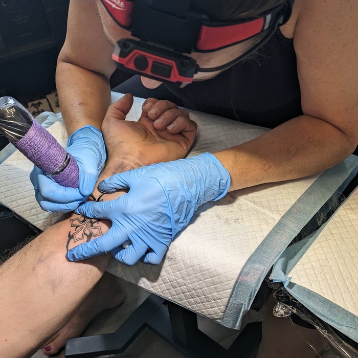 Karine réalisant son premier vrai tatouage